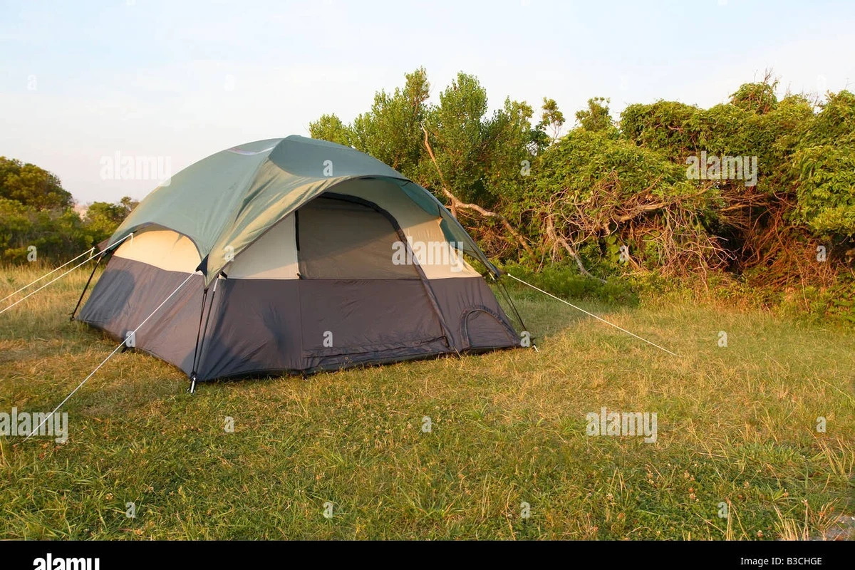 Sleeping bag laid flat for cleaning and drying beside camping gear