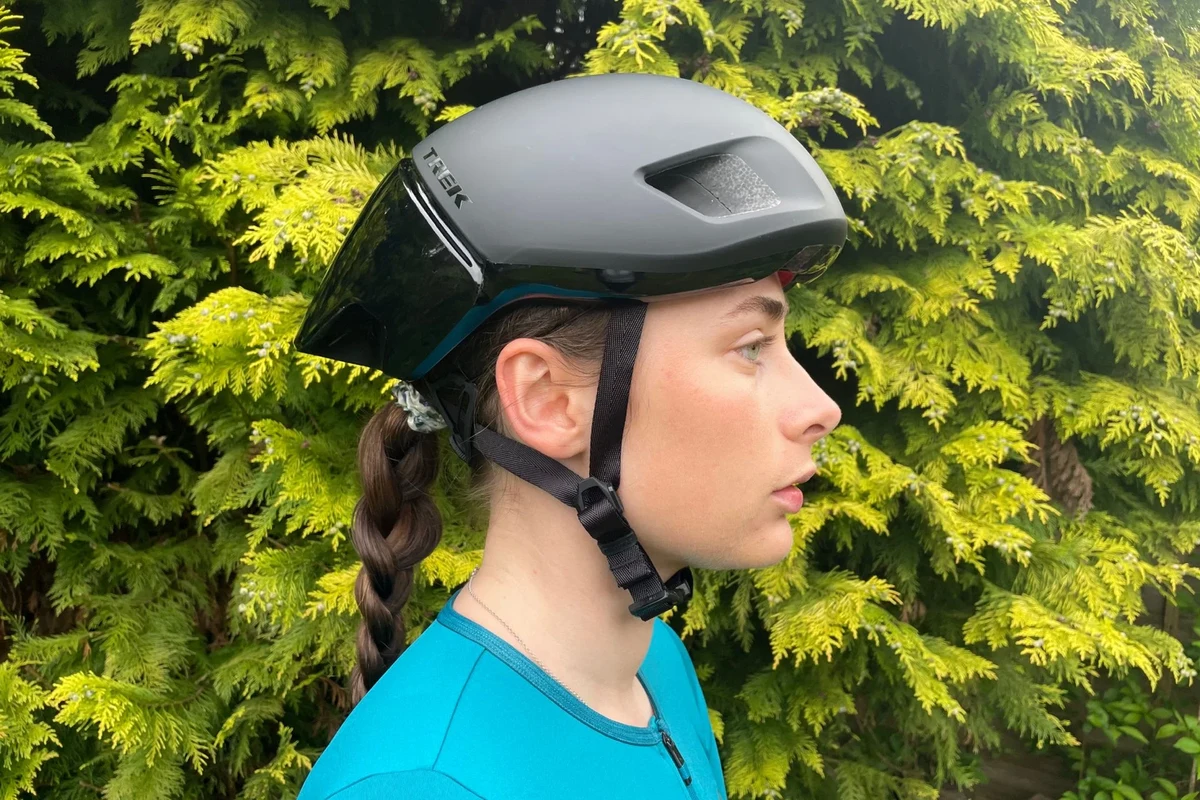Cyclist wearing an illuminated e-bike helmet at dusk in city traffic